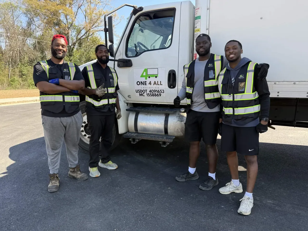 One4all Logistics crew standing beside a branded box truck.