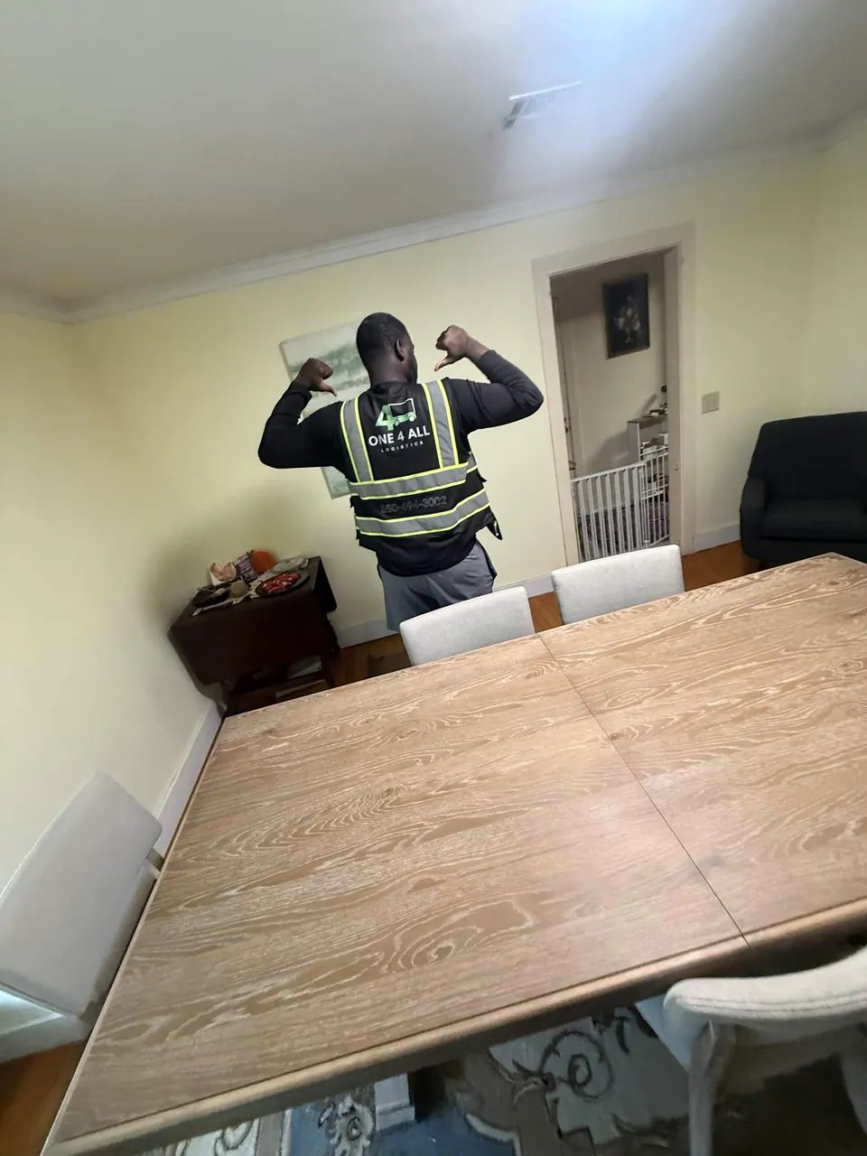 One4all Logistics team member beside a dining table inside a home.